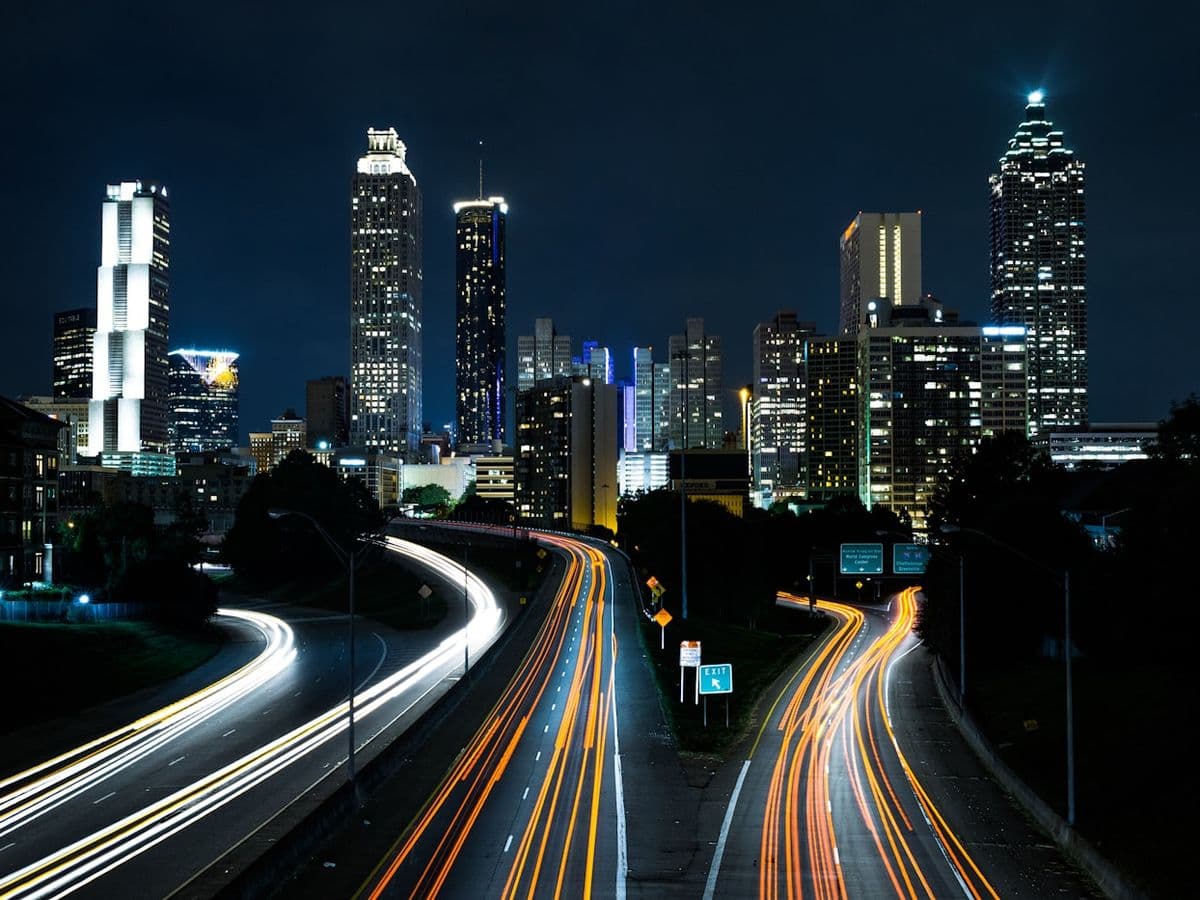 The Atlanta skyline at night with traffic light trails on the highway below