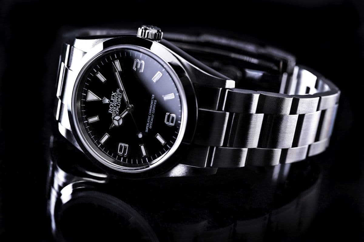 Black and white photograph of a stainless steel Rolex on a dark surface